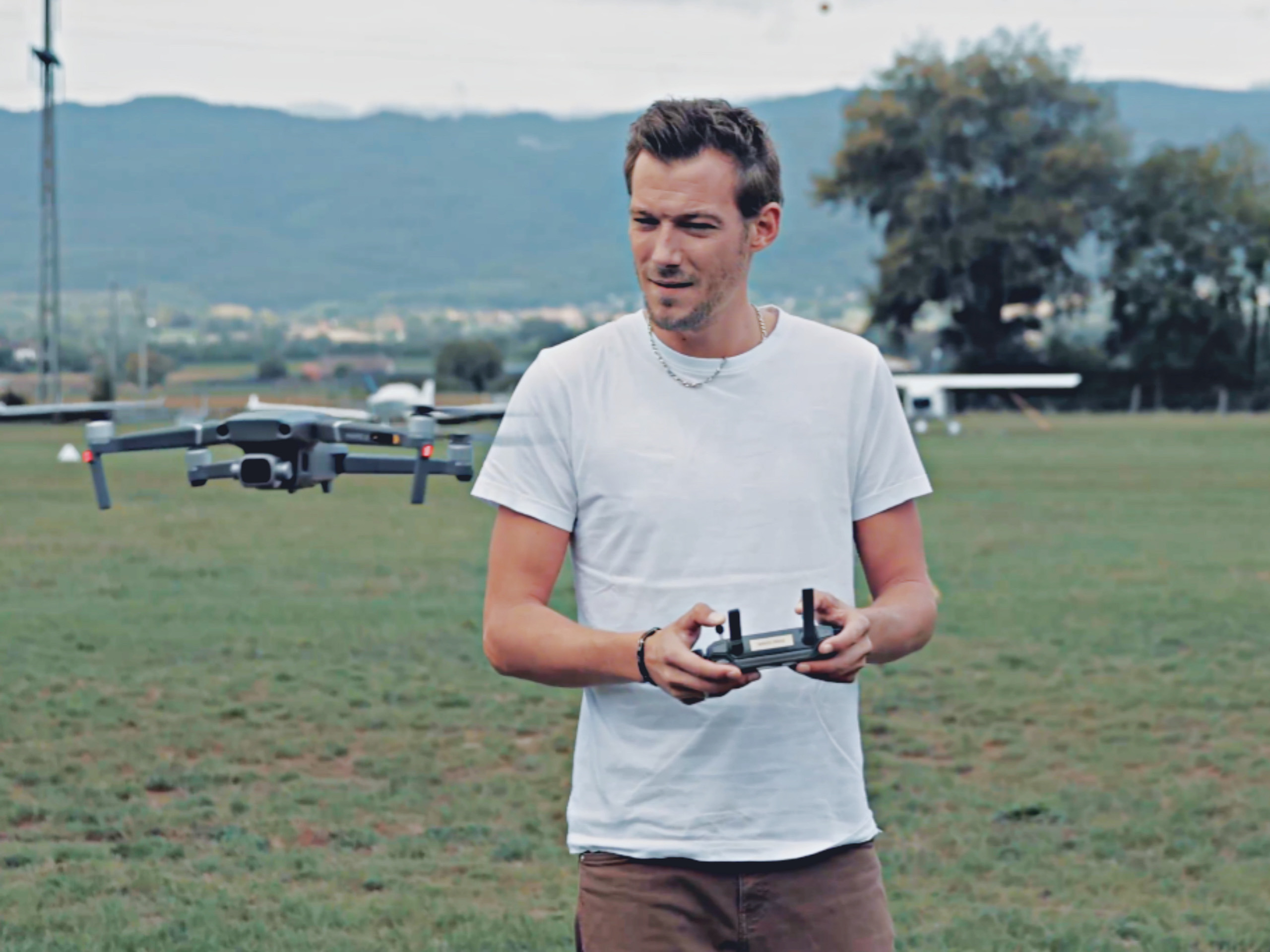 un homme qui télépilote un drone avec une manette