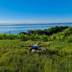 drone d'épandage aero 41 dans les vignes du lavaux avec le lac léman en fond